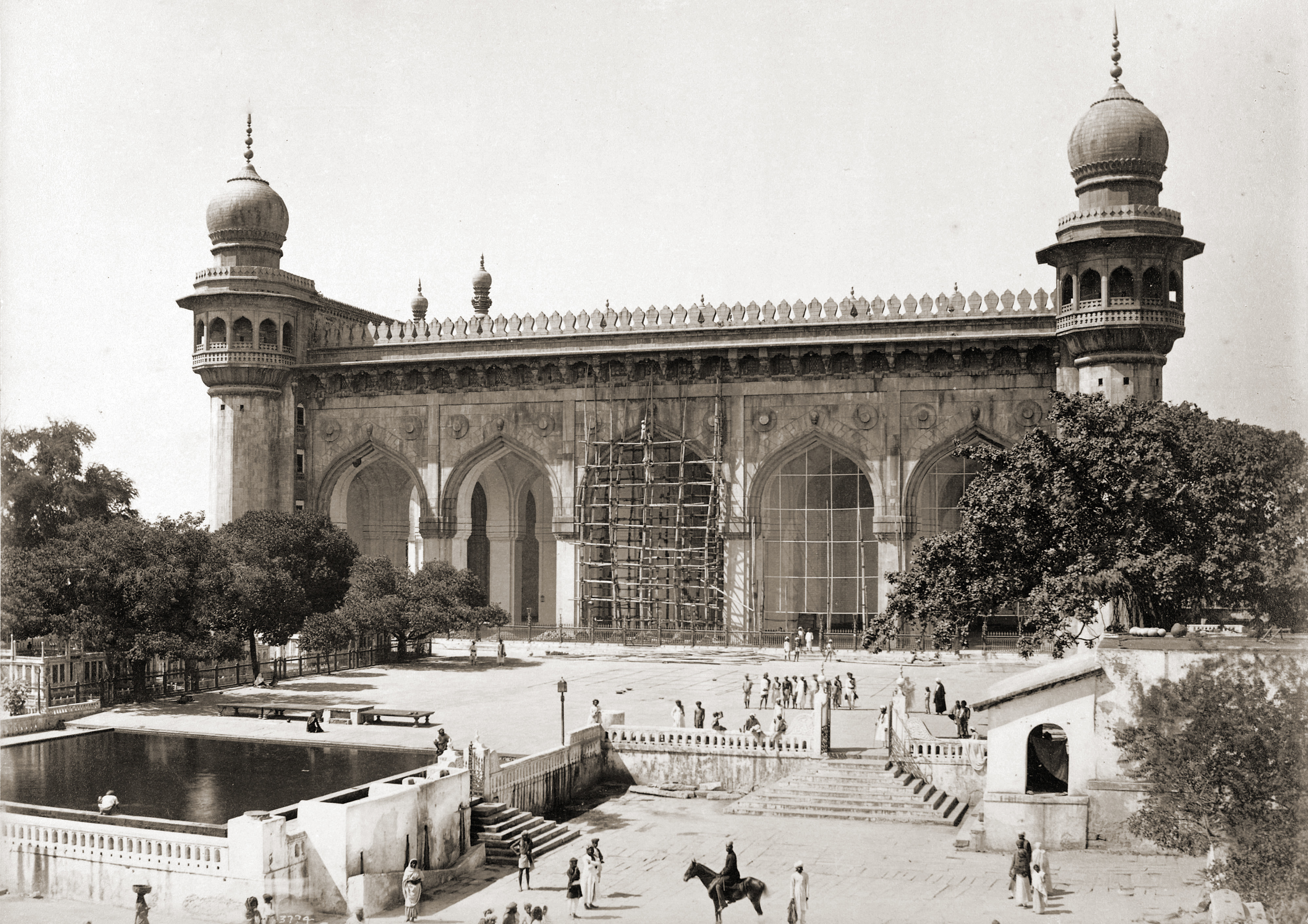  Hindistan'daki Mekke mescidinin Deen Dayal tarafından 1880'ler çekilmiş bir fotoğrafı. Avlusunda yerel halkta insanlar görülüyor.