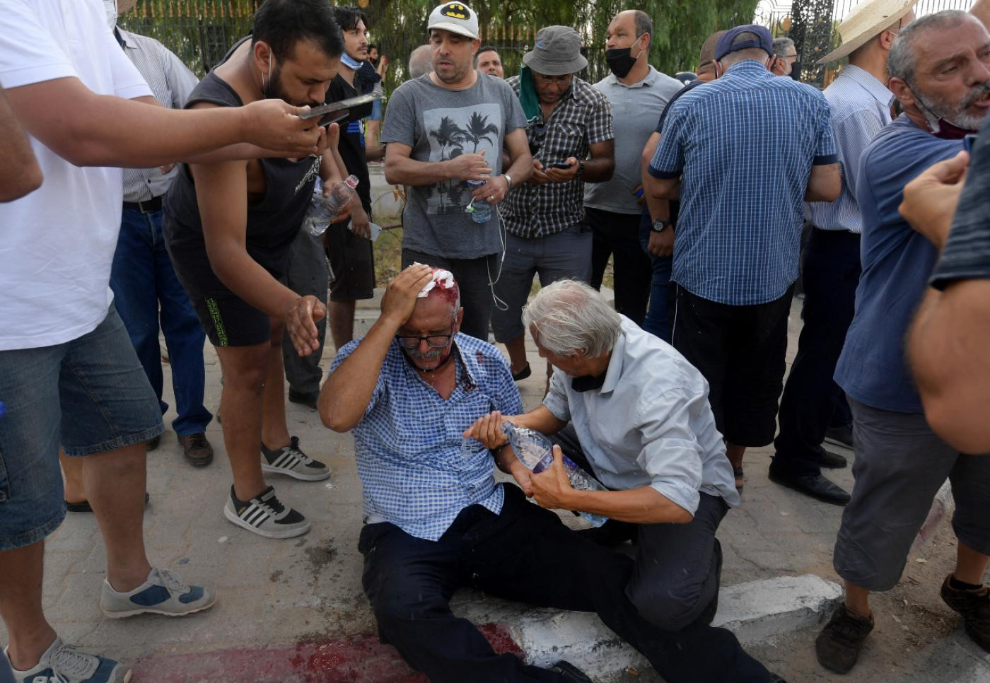 Tunus polisi tarafından saldırıya uğramış bir darbe karşıtı Tunuslu. 