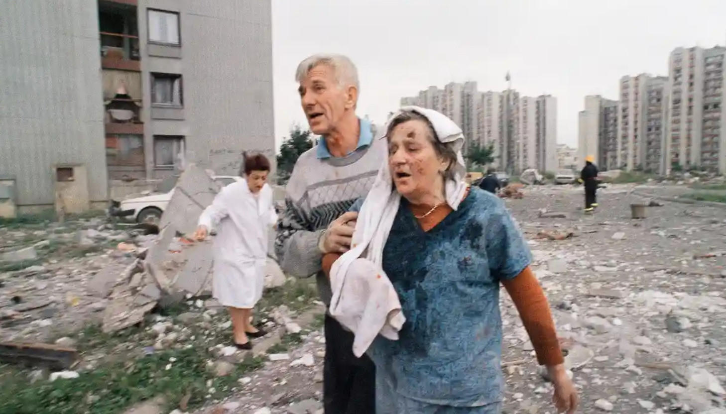 Bosnalı Sırp mevzilerinden atılan bir roketin isabet ettiği apartmandaki yaralı bir kadına yardım ediliyor, Haziran 1995.