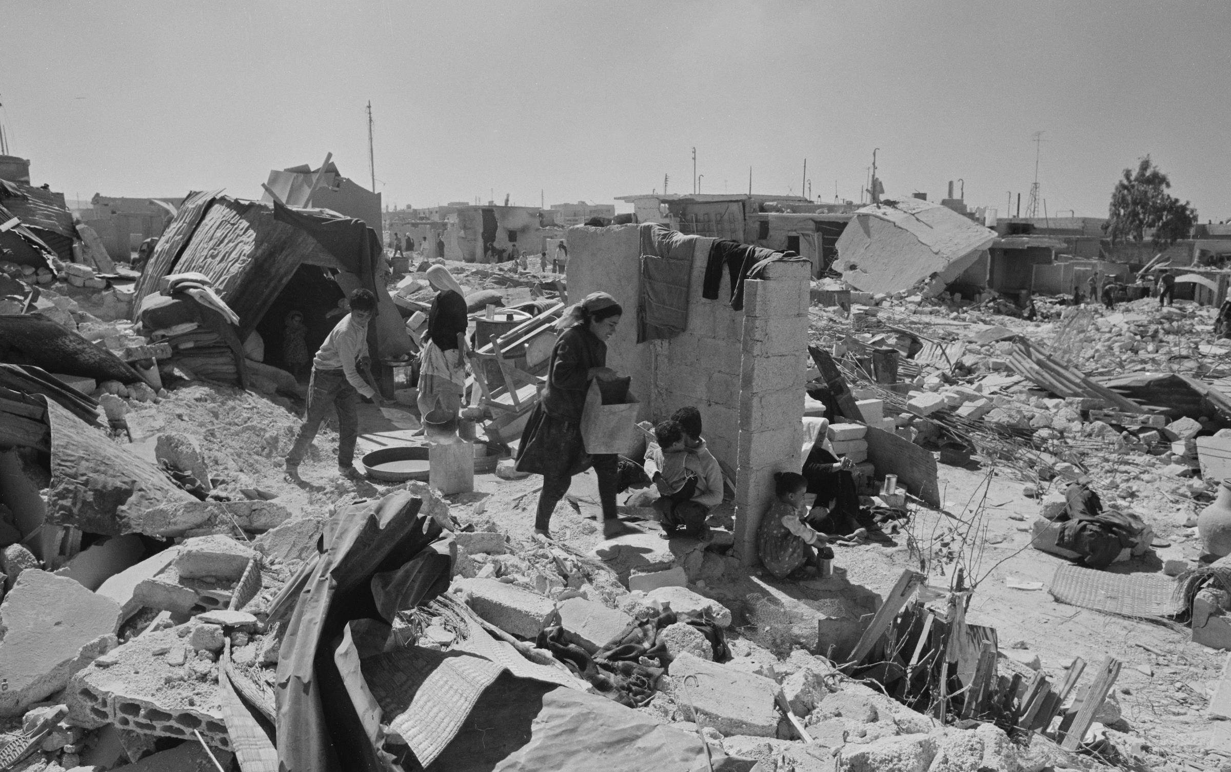 Kara Eylül'ün ardından molozlar arasında günlük işlerine devam eden Filistinli mülteciler.